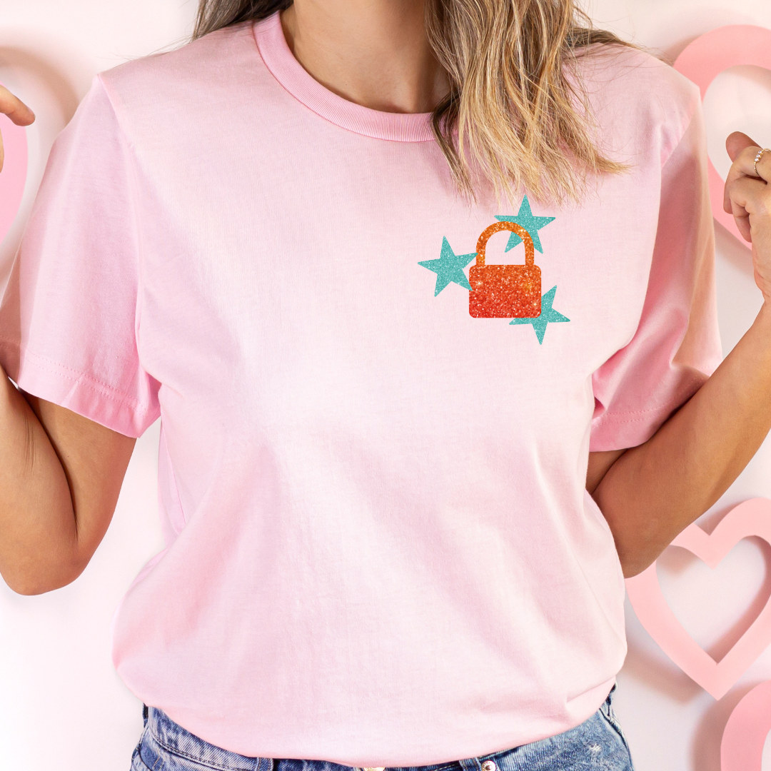 Person wearing a pink t-shirt with a colorful handbag design on a heart-shaped background