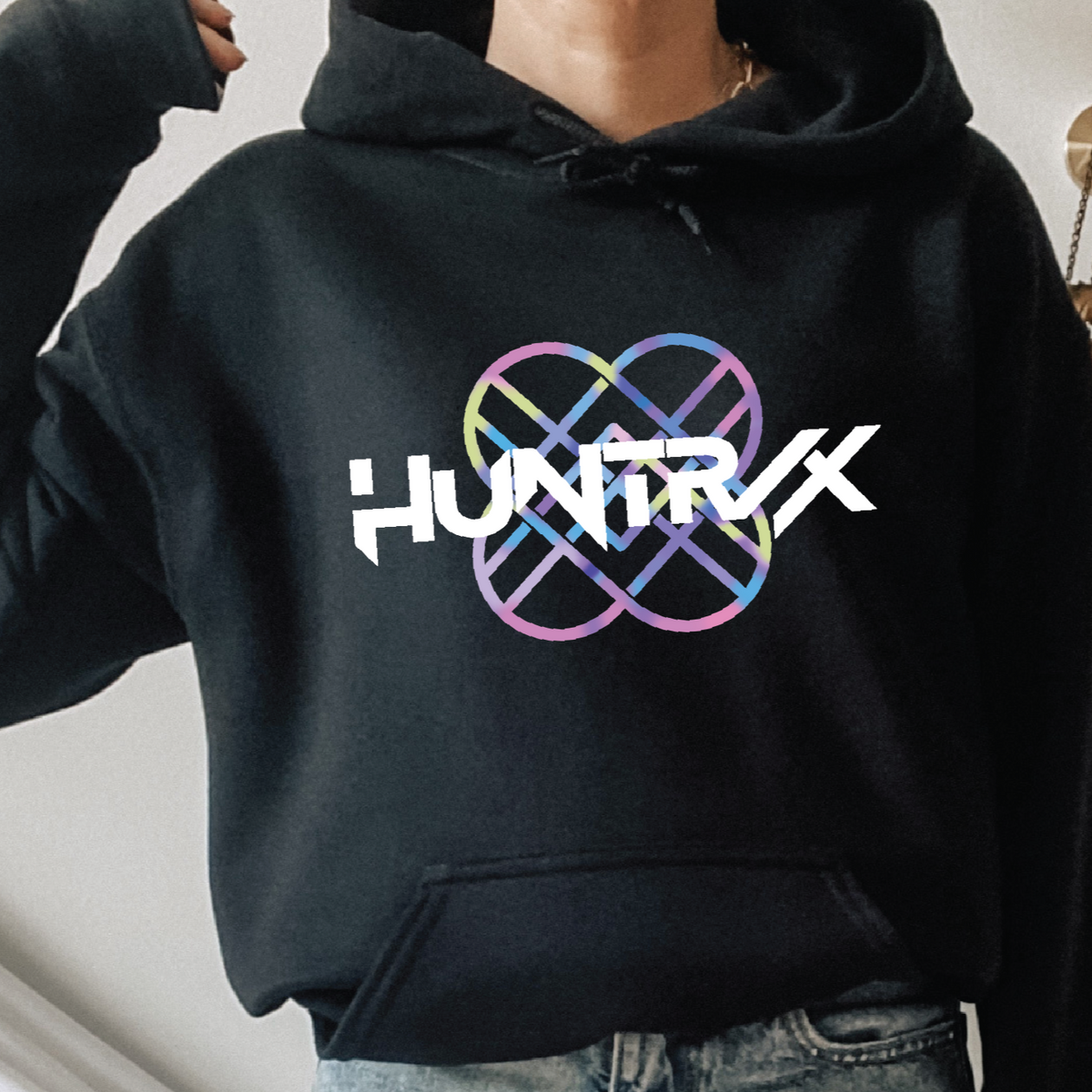 Person wearing a black hoodie with 'HUNTRX' logo.