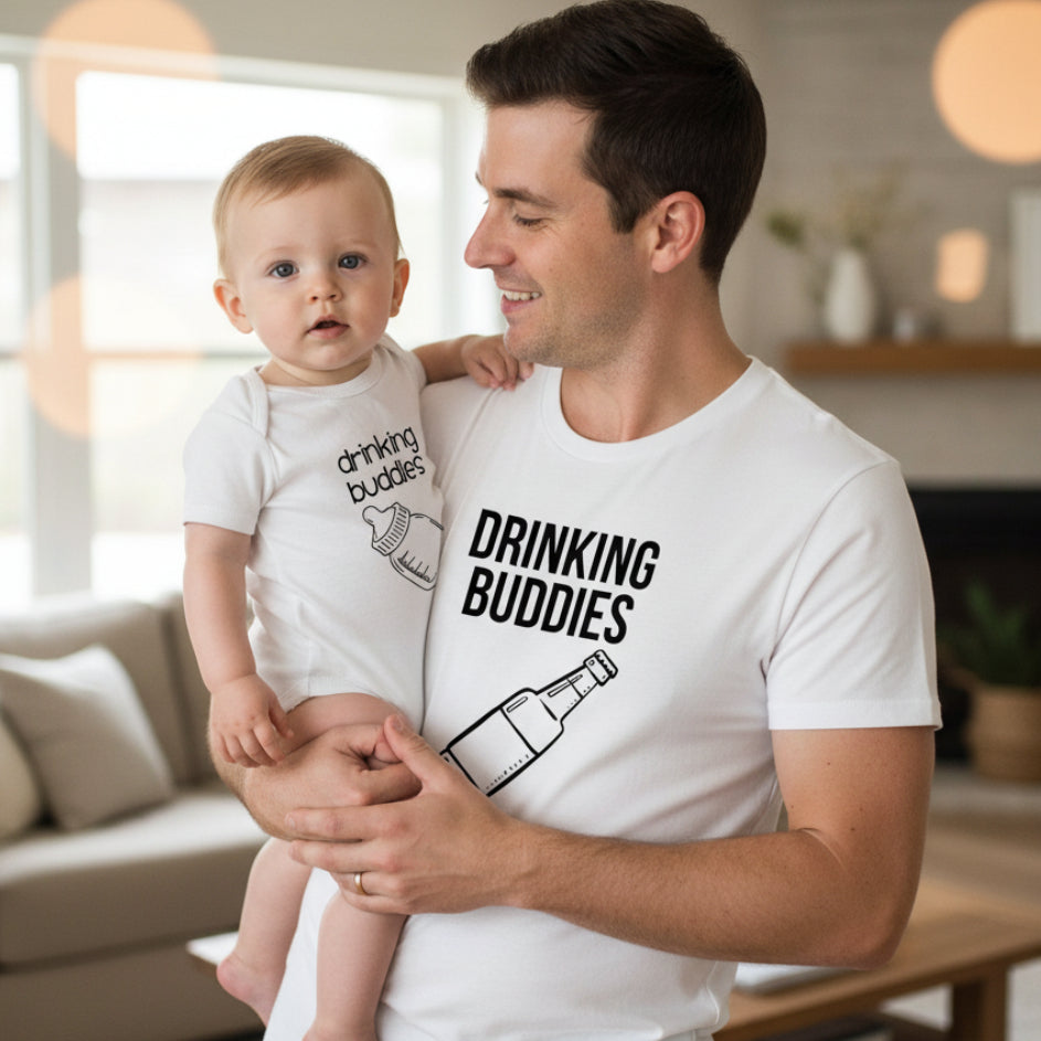 A white t-shirt and a matching baby bodysuit with the text 'DRINKING BUDDIES' and an illustration of a beer bottle on the front.