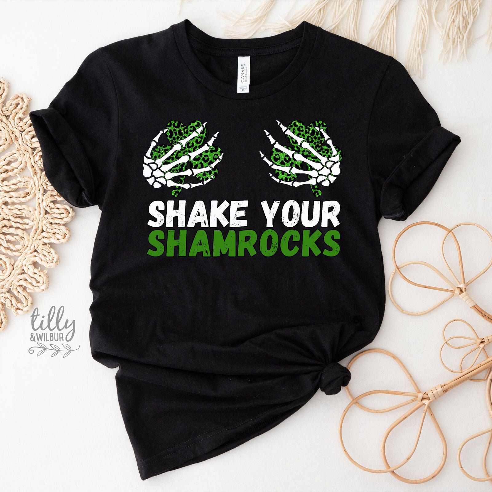 Black t-shirt with 'Shake Your Shamrocks' text and skeleton hand graphics on a white background.