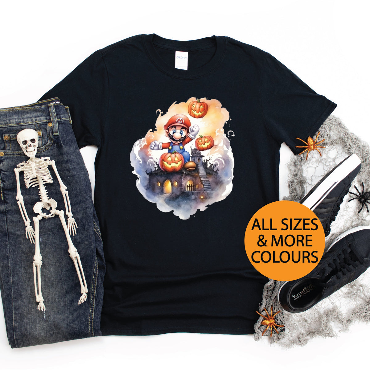 Black t-shirt with Halloween-themed design, jeans, shoes, and skeleton on a white background.