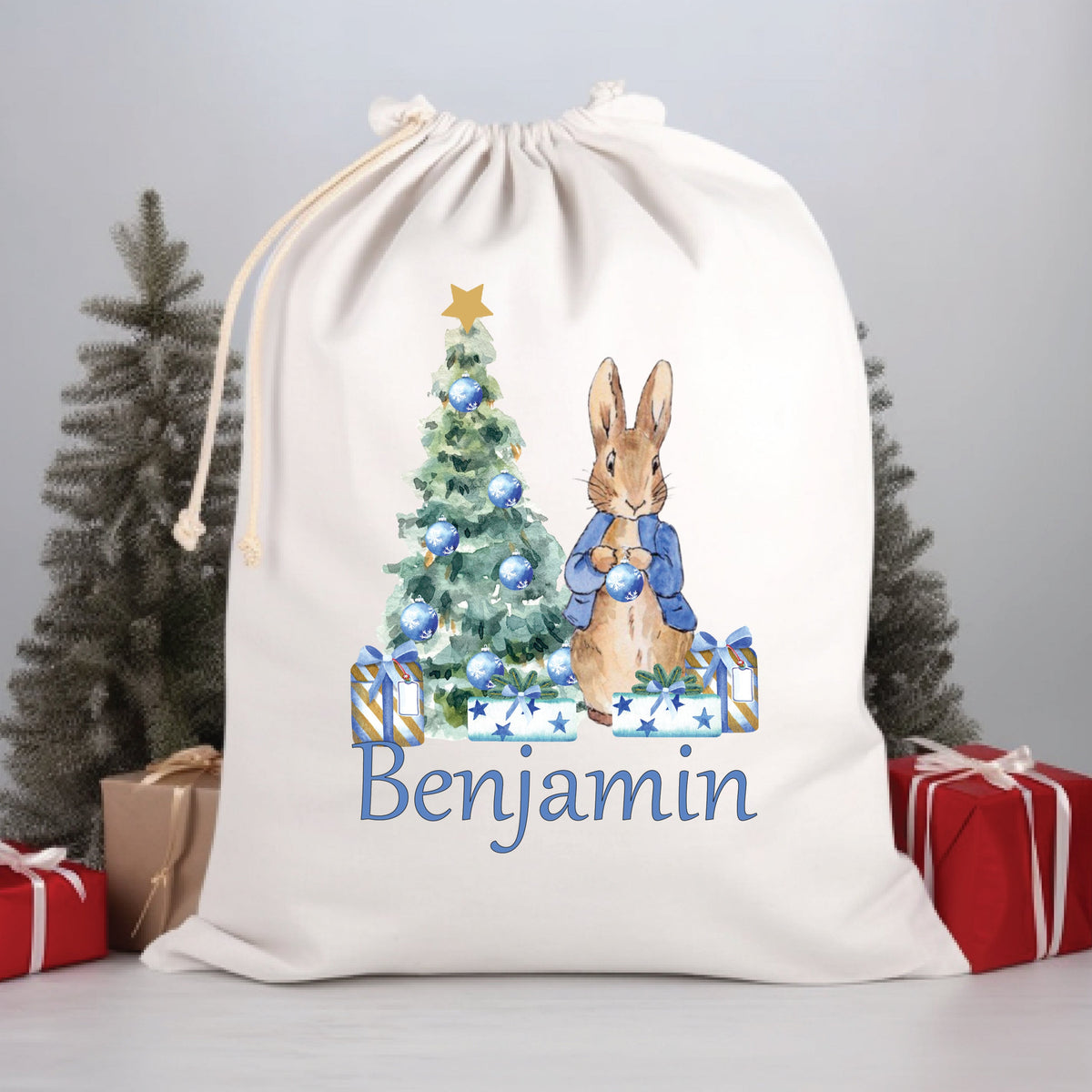 A beige Santa sack with a Christmas tree and a cartoon rabbit design, personalized with the name 'Benjamin' on the front.