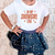 Child wearing a white t-shirt with 'IN MY SHOWGIRL ERA' text and a navy blue star-patterned skirt.