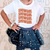 Child wearing a white t-shirt with 'SHOWGIRL' text and a navy blue star-patterned skirt.