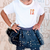 Child wearing a white t-shirt with 'T.S.' and a navy blue tutu with star patterns.