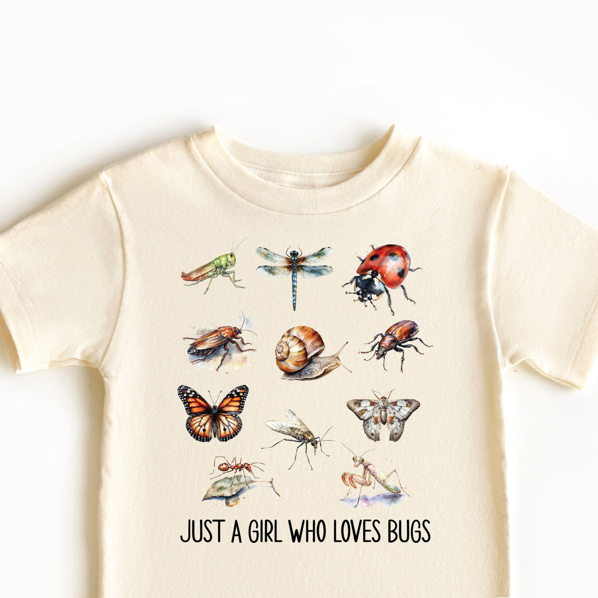 A beige t-shirt with a graphic print of various insects and the text &#39;Just a girl who loves bugs&#39;.