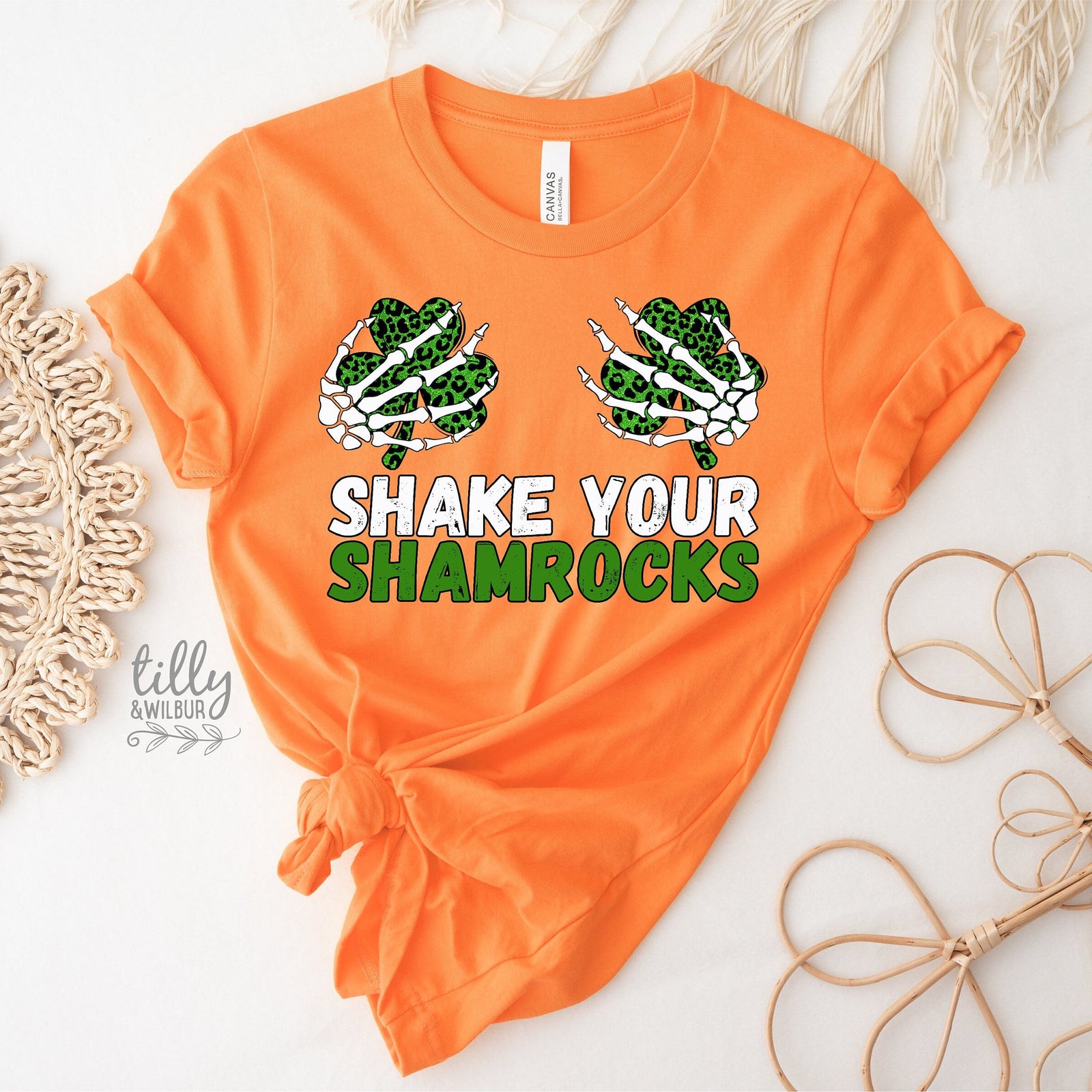 Orange t-shirt with 'Shake Your Shamrocks' text and graphic on a light background