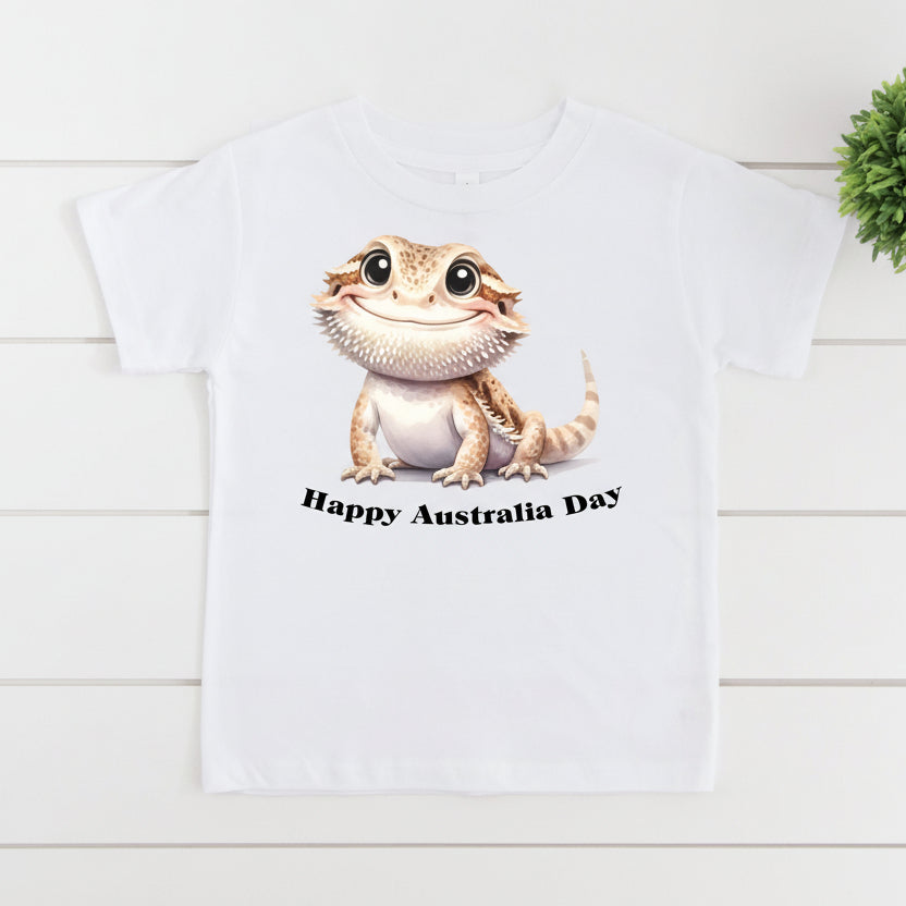 White t-shirt with a cartoon lizard and 'Happy Australia Day' text on a white background