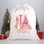 A white Christmas-themed drawstring sack featuring an illustration of a cartoon rabbit in Santa's outfit, with Christmas trees and gifts around it.