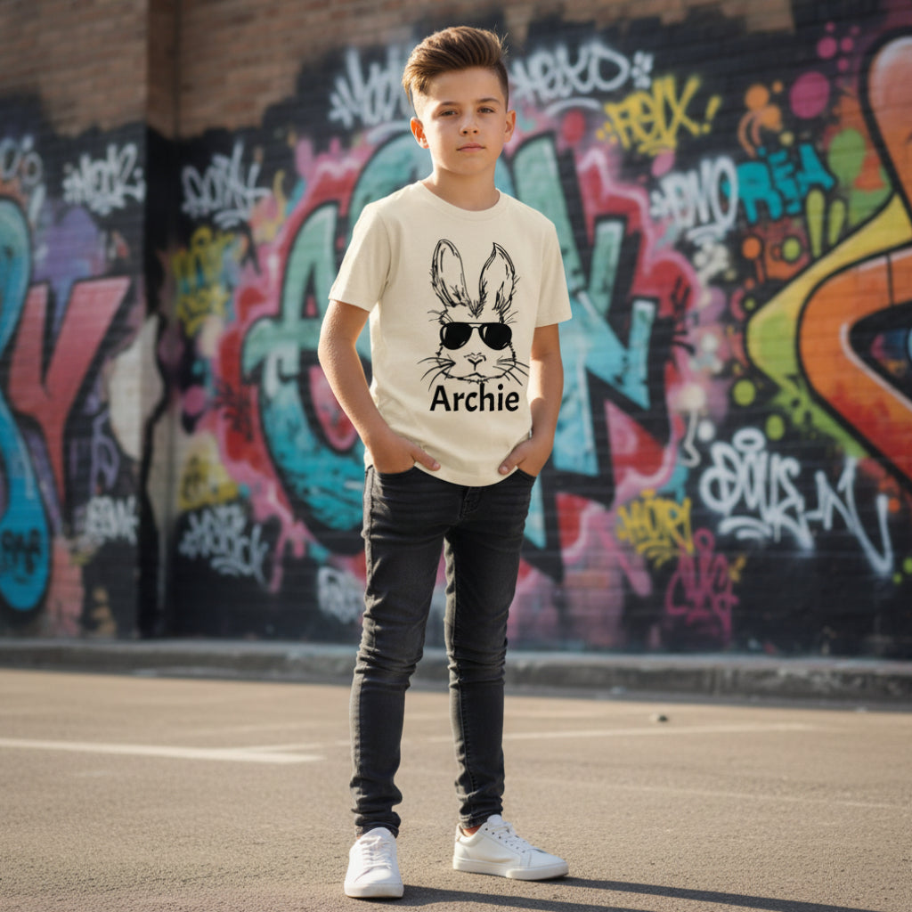 Beige t-shirt with a graphic of a rabbit wearing sunglasses and the name 'Archie' on a white background